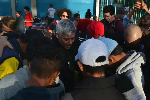 Pastor Fabian Arias of Iglesia de Sion, a Spanish-speaking congregation in Midtown Manhattan, prays with asylum-seekers outside of Benito Juarez shelter
